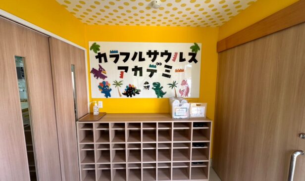 完了写真<エントランス><br />
エントランスホールは一番最初に子供達を迎え入れる場所。<br />
飾り気のなかった雰囲気から黄色と木柄で温かみある空間へ。
