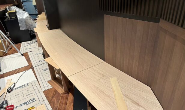 最終仕上げにカウンター背面へ大型ディスプレイ家具を設置していきます。<br />
R曲線の壁面への家具の設置は難易度が高く、綿密な現地採寸をもとに職人技で仕上げていきます。