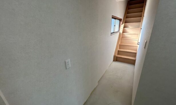 <2F内装工事完了写真　階段フロア><br />
既設の裏勝手口は撤去し、塞ぎました。<br />
階段も新しく安心・安全なものに交換しました。